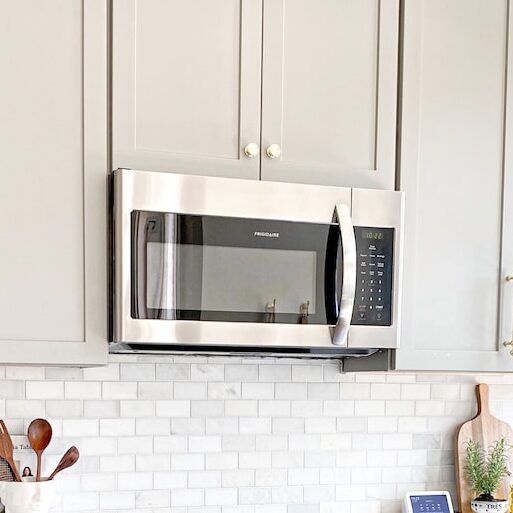 white microwave oven on white wooden cabinet