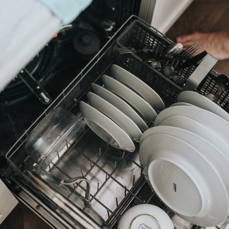 white ceramic plate on black dishwasher